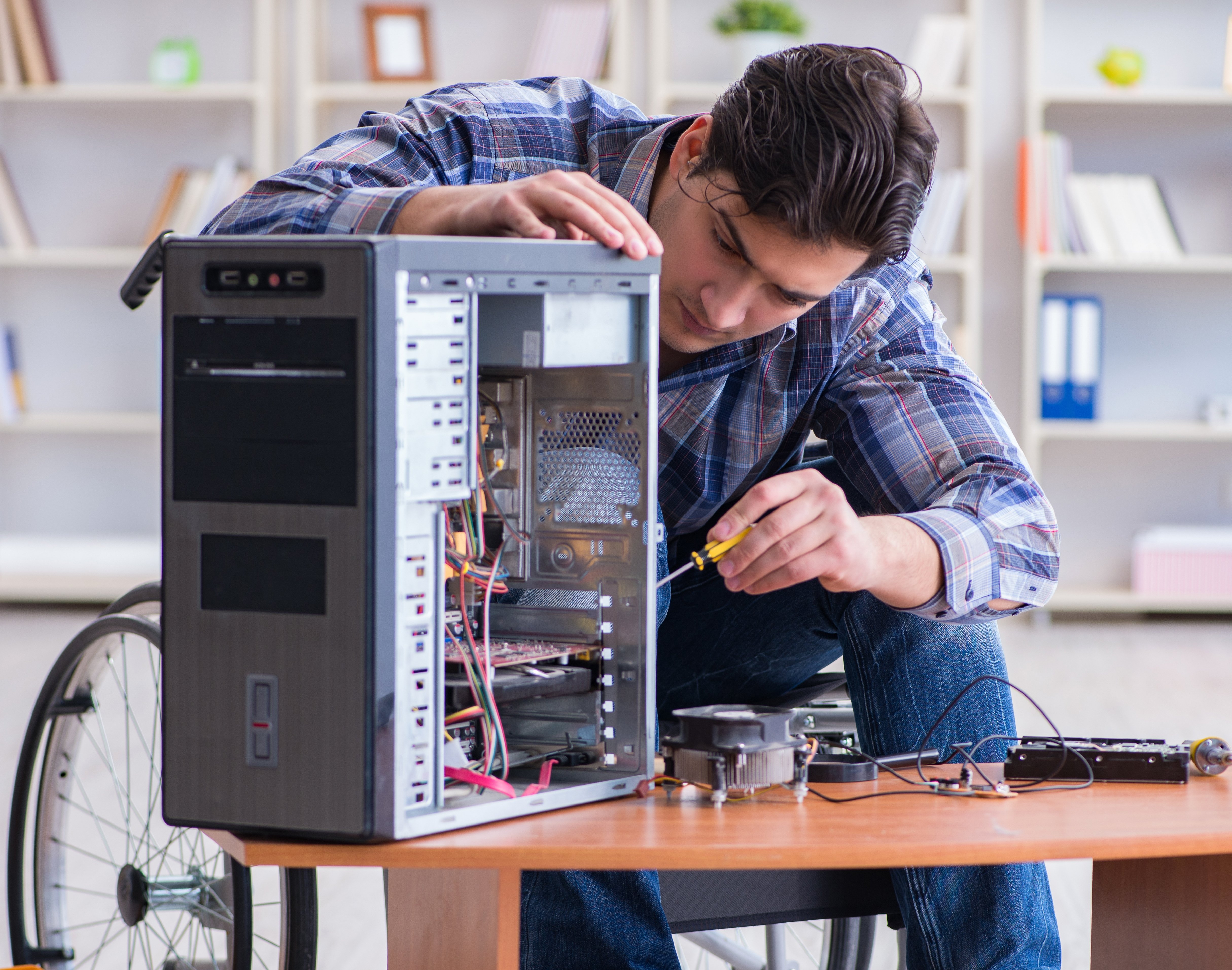 Medewerker refurbisht computerhardware in een inclusieve werkomgeving, gericht op hergebruik en verlenging van de levensduur van IT-apparatuur.